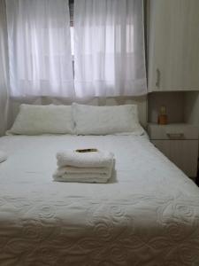 uma cama branca com duas toalhas em cima em SUH Apartment em Buenos Aires