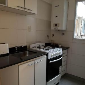 ブエノスアイレスにあるSUH Apartmentのコンロとシンクのあるキッチン