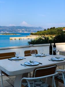 a table with wine glasses and a view of the ocean at Holiday Home Adriatic in Lumbarda