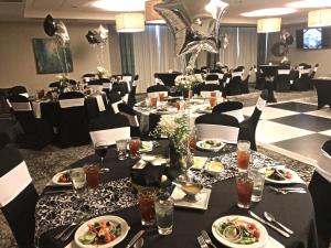 uma sala de jantar com mesas e cadeiras com pratos de comida em Holiday Inn & Suites Denver Tech Center-Centennial, an IHG Hotel em Centennial