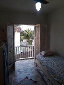 a bedroom with a bed and a door to a balcony at Apartamento na enseada 50 metros da praia in Guarujá