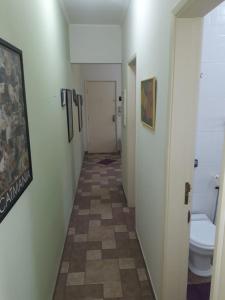 a hallway of a bathroom with a toilet and a hallway at Apartamento na enseada 50 metros da praia in Guarujá