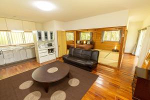 uma sala de estar com um sofá de couro e uma mesa em Villa Itona em Ishigaki Island