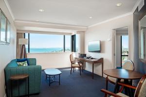 a hotel room with a couch and a table and a desk at The Spencer Hotel in Auckland