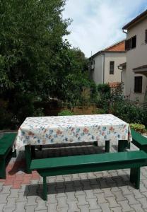 a green picnic table with a table cloth on it at Apartments Ruzica - 50 m from sea in Jezera