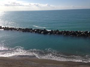 un grupo de rocas en el agua en la playa en Hotel San Pietro Chiavari, en Chiavari
