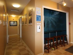 un couloir avec des chaises et un tableau noir sur le mur dans l'établissement HI Point Montara Lighthouse, à Montara