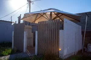 an umbrella on top of a white fence at Relaxing Guest House in th Heart of Ndabeni in Cape Town