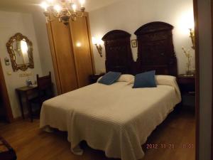 a bedroom with a large bed with blue pillows on it at Hotel Azkue in Getaria