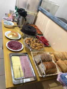un buffet con diferentes tipos de comida en una mesa en Pousada do sol, en Torres