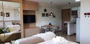 ein Wohnzimmer mit einem Sofa und eine Küche mit einem Tisch in der Unterkunft Flat Vista Azul - Pedra Azul ES in Pedra Azul