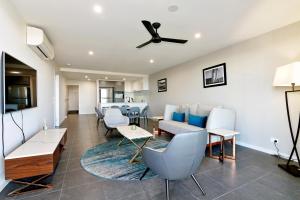 a living room with chairs and a ceiling fan at Hedge Apartments by CLLIX in Buddina