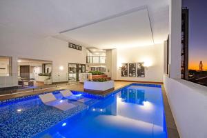 an indoor swimming pool in a house at Hedge Apartments by CLLIX in Buddina