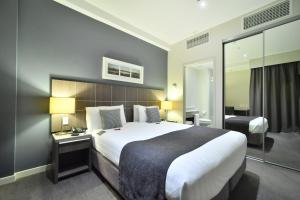 a hotel room with a large bed and a desk at Quest Highbrook in Auckland