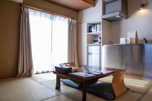 sala de estar con mesa de madera y ventana en Address Nozawa, en Nozawa Onsen