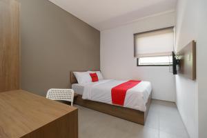 a small bedroom with a bed and a window at RedDoorz Syariah near Rumah Sakit Medika Dramaga in Bogor