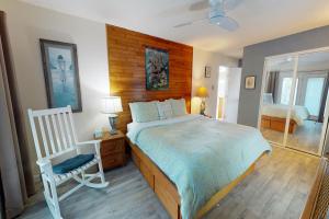 1 dormitorio con 1 cama grande y 1 silla en Taylor's Perch en Galveston