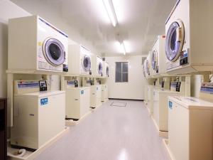 a laundry room with white washers and dryers at La'gent Inn Kesennuma in Kesennuma