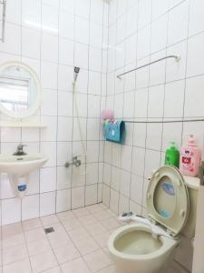Baño de azulejos blancos con aseo y lavamanos en Xiangyang Tianyuan Ju Homestay, en Dongshan