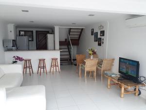 a living room with a table and chairs and a television at Casa em Angra dos Reis no Paraíso do Condomínio do Engenho in Angra dos Reis
