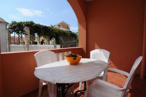 a white table and chairs with a bowl of fruit on it at Vila Apartments Lidija in Petrovac na Moru