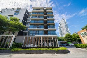 a building with a sign in front of it at Altera Hotel and Residence by At Mind in Pattaya