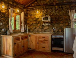 a kitchen with a stove and a refrigerator at Honeymoon Hut in Naivasha