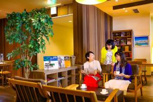 a woman and two girls sitting in a room at Ooedo Onsen Monogatari Hotel Reoma no Mori in Marugame