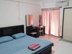 彭世洛ทองธิดาอพาร์ทเม้นท์的一间卧室,床上放着手提箱