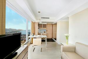 uma sala de estar com televisão e uma sala de estar com vista em Harbour Plaza 8 Degrees em Hong Kong