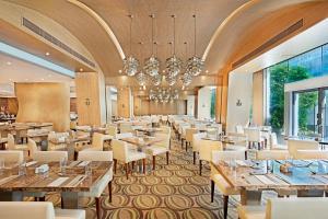 una sala da pranzo con tavoli, sedie e lampadario a braccio di Harbour Plaza 8 Degrees a Hong Kong