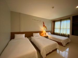 曼谷的住宿－CHERN Bangkok，酒店客房设有两张床和窗户。
