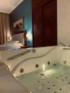 a bath tub in a hotel room with a bed at Hotel Flora in Noto