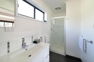 大廳峽的住宿－霍爾斯加普汽車旅館，白色的浴室设有水槽和淋浴。