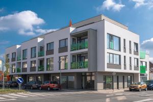 a building with cars parked in a parking lot at Grunt Apartments in Mladá Boleslav
