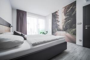 sypialnia z łóżkiem z obrazem na ścianie w obiekcie Grunt Apartments w mieście Mladá Boleslav