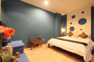 a bedroom with a bed and a blue wall at Golden Ocean Azure Hotel in Kenting