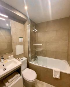 La salle de bains est pourvue de toilettes, d'une baignoire et d'un lavabo. dans l'établissement Hotel de Bordeaux, à Toulouse