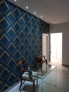 une chambre avec une table en verre et un mur bleu dans l'établissement B&B Miglio Sacro, à Naples