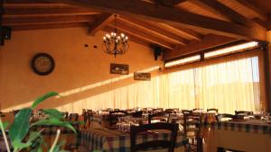 a dining room with tables and chairs and a chandelier at Agriturismo Il Sesto Senso in Ladispoli