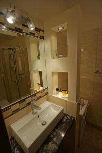 a bathroom with a sink and a mirror and a shower at Apartament Amber in Sopot