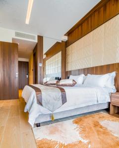 a large bedroom with two beds and a wooden wall at Leonardo Boutique Hotel Larnaca in Larnaca