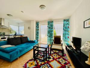 ein Wohnzimmer mit einem blauen Sofa und einem Tisch in der Unterkunft Ferienwohnungen Birkenhof in Bad Wörishofen