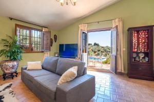 a living room with a couch and a sliding glass door at Hacienda la buena vida B&B en appartementen in Algarinejo