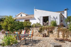 a table and chairs in front of a house at Hacienda la buena vida B&B en appartementen in Algarinejo