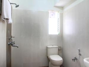 łazienka z toaletą, umywalką i oknem w obiekcie Hotel Siri Inn w mieście Hajdarabad