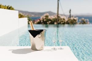 a bottle of champagne in a bucket next to two wine glasses at Paros Agnanti Resort & Spa in Parikia