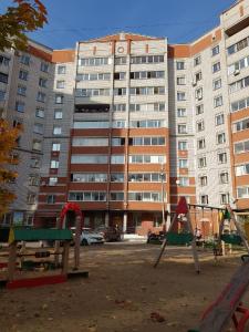 an empty playground in front of a large building at Апартаменты на Новгородской 4 in Vologda