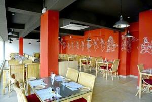 a dining room with red walls and tables and chairs at Hotel Siri Inn Hitech City in Hyderabad