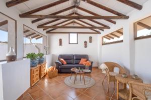 a living room with a blue couch and a table at Hacienda la buena vida B&B en appartementen in Algarinejo